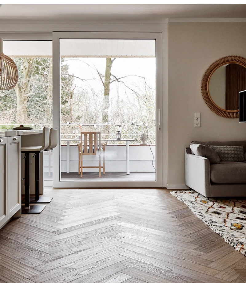 Blick auf die Balkontür in einem Designer Apartment in Düsseldorf. Man sieht links einen Teil der weißen Küche und rechts einen Teil vom Sofa.